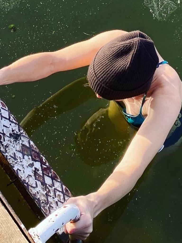 Eine Frau beim Eisbaden im See; nach dem Bad steigt sie die Leiter hoch, auf dem Wasser ist eine dünne Eisschicht zu sehen. Eine Frau beim Eisbaden im See; nach dem Bad steigt sie die Leiter hoch, auf dem Wasser ist eine dünne Eisschicht zu sehen.
