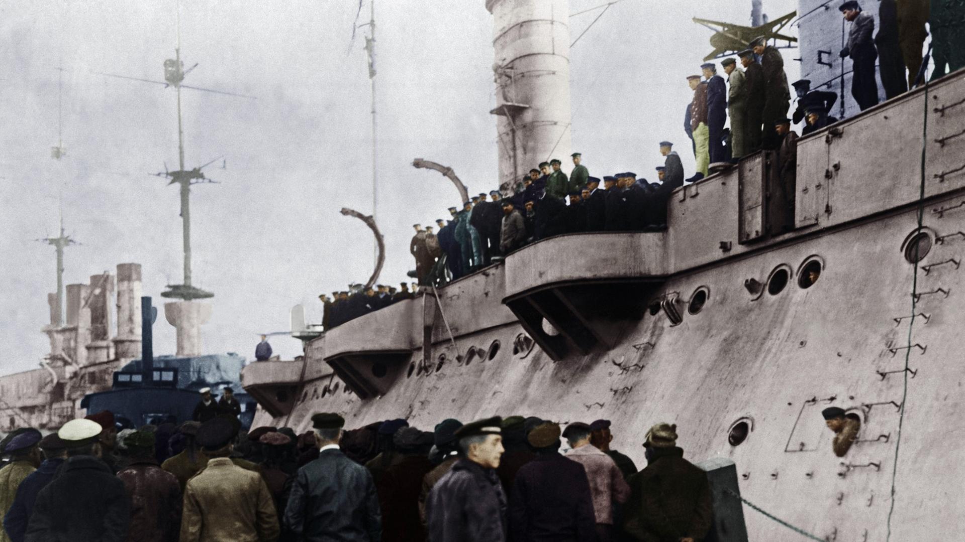 Zahlreiche Matrosen der Hochseeflotte stehen auf und vor einem der U-Boote, digital koloriertes Foto vom 5.11.1918