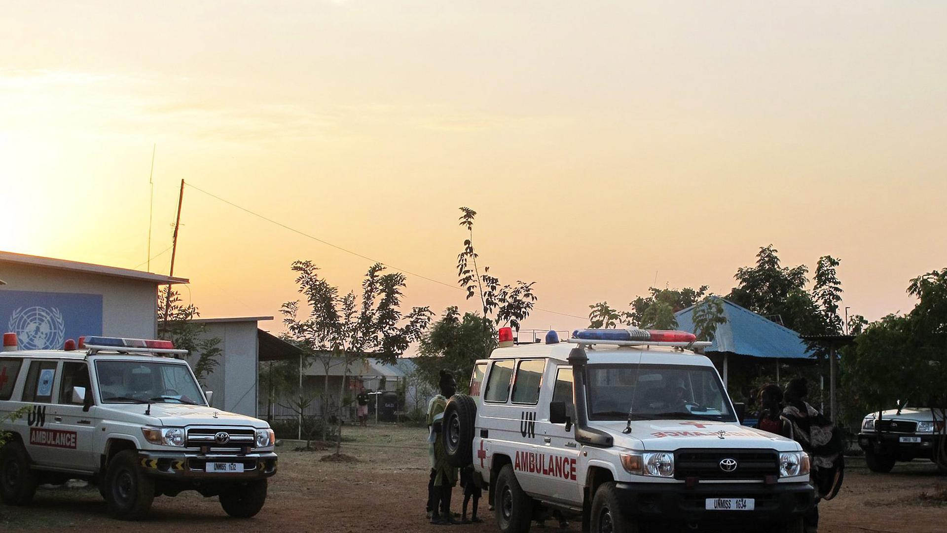 Zwei Autos der UNO halten auf einem Platz im Südsudan.