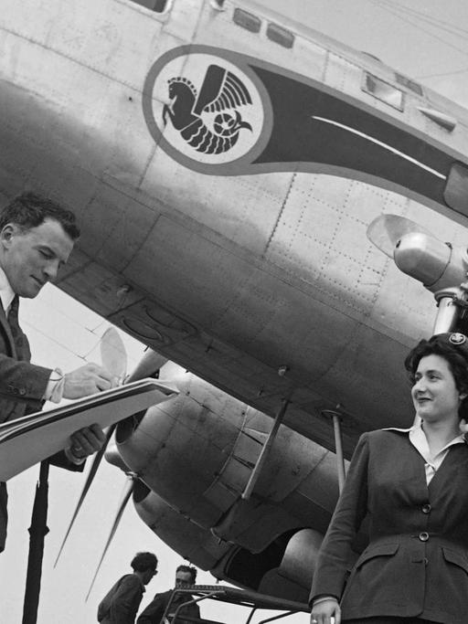 Eine Stewardess der Air France steht im Jahre 1949 Modell vor einem DC3-Flugzeug auf dem Flughafen Le Bourget