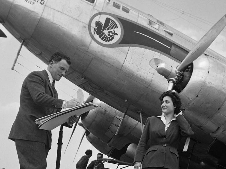 Eine Stewardess der Air France steht im Jahre 1949 Modell vor einem DC3-Flugzeug auf dem Flughafen Le Bourget