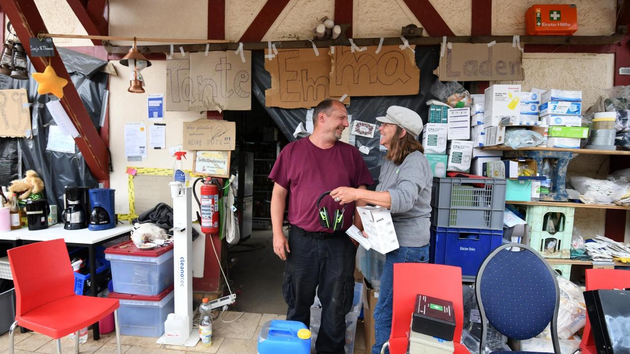 Freiwillige organisieren Hilfe in einem Laden für die Flutopfer in Dernau. Auf dem Schild über den Köpfen steht auf einem selbstgemalten Schild: Tante Emma Laden. 19. August 2021.