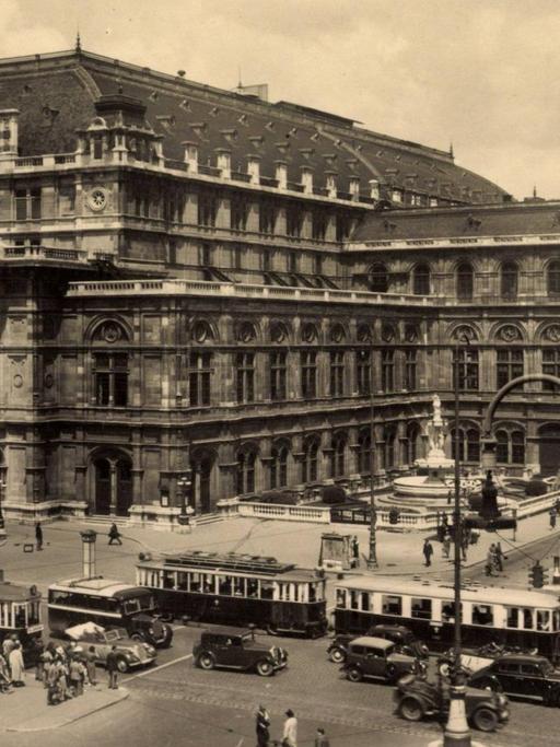 Die Staatsoper Wien in der Altstadt, Schwarz-Weiß-Aufnahme aus den 1930er Jahren, mit Straßenbahn- und Auto-Verkehr