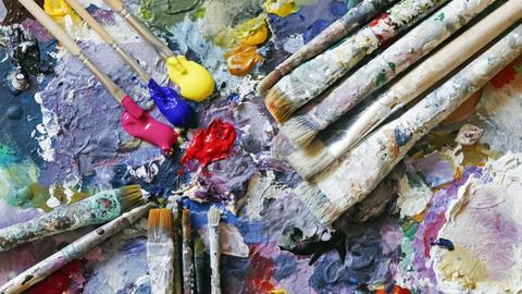 Farben und Pinsel auf der Palette eines Künstlers