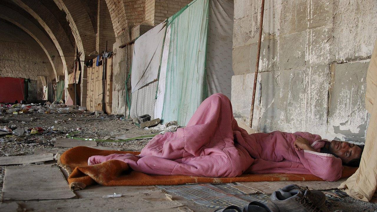 Ein Flüchtling schläft im alten Hafen von Triest