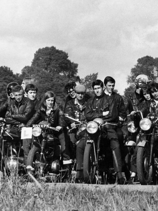 Rockergruppe posiert mit Motorrädern in den 1970er Jahren für ein Foto. 