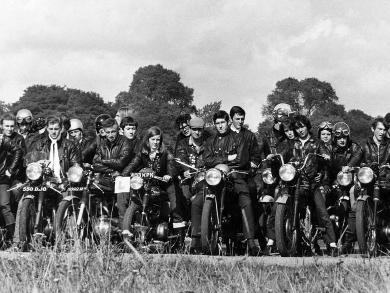 Rockergruppe posiert mit Motorrädern in den 1970er Jahren für ein Foto. 