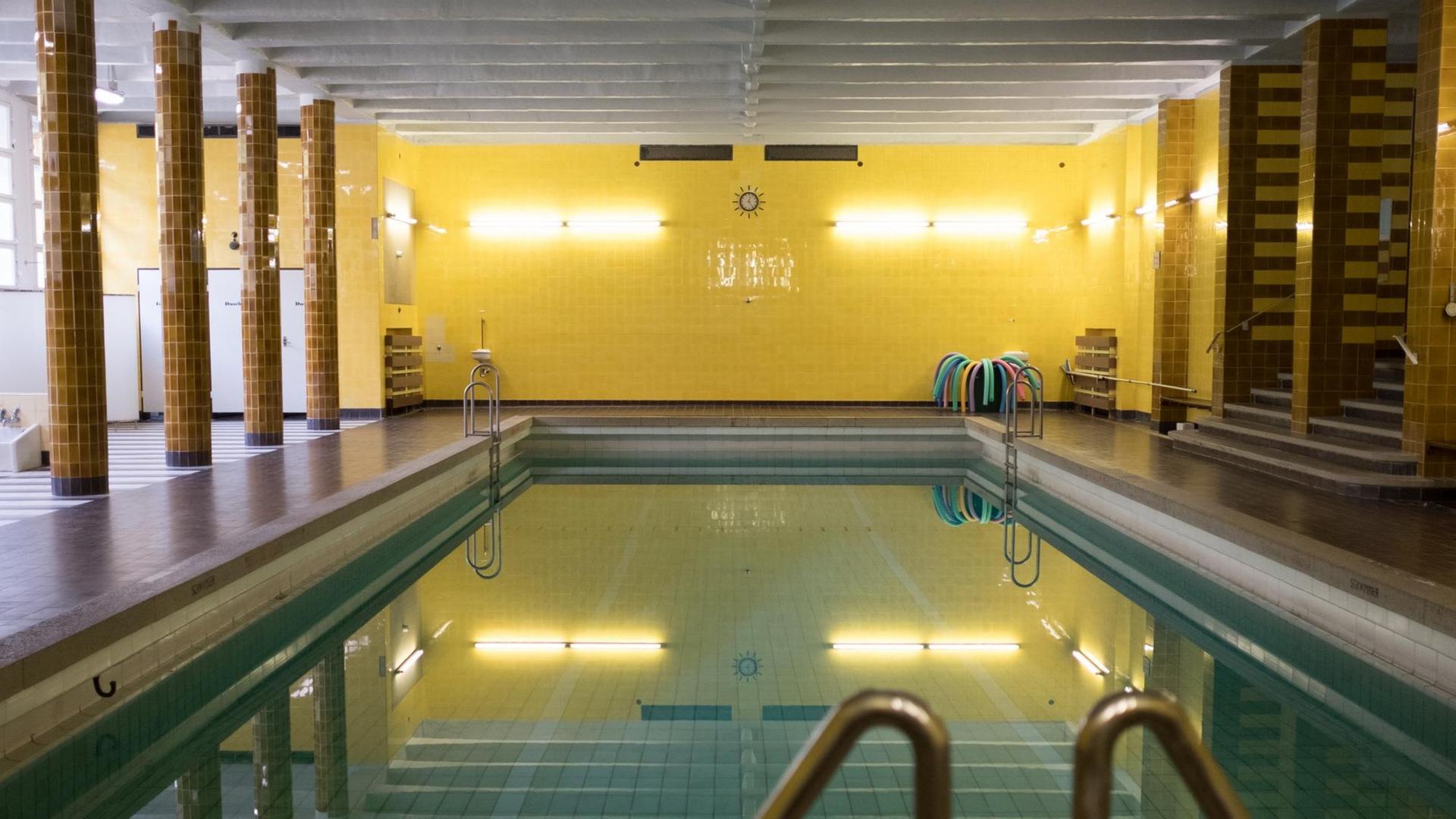 Ein Schwimmbecken, links und rechts zum Becken stehen Säulen im Raum