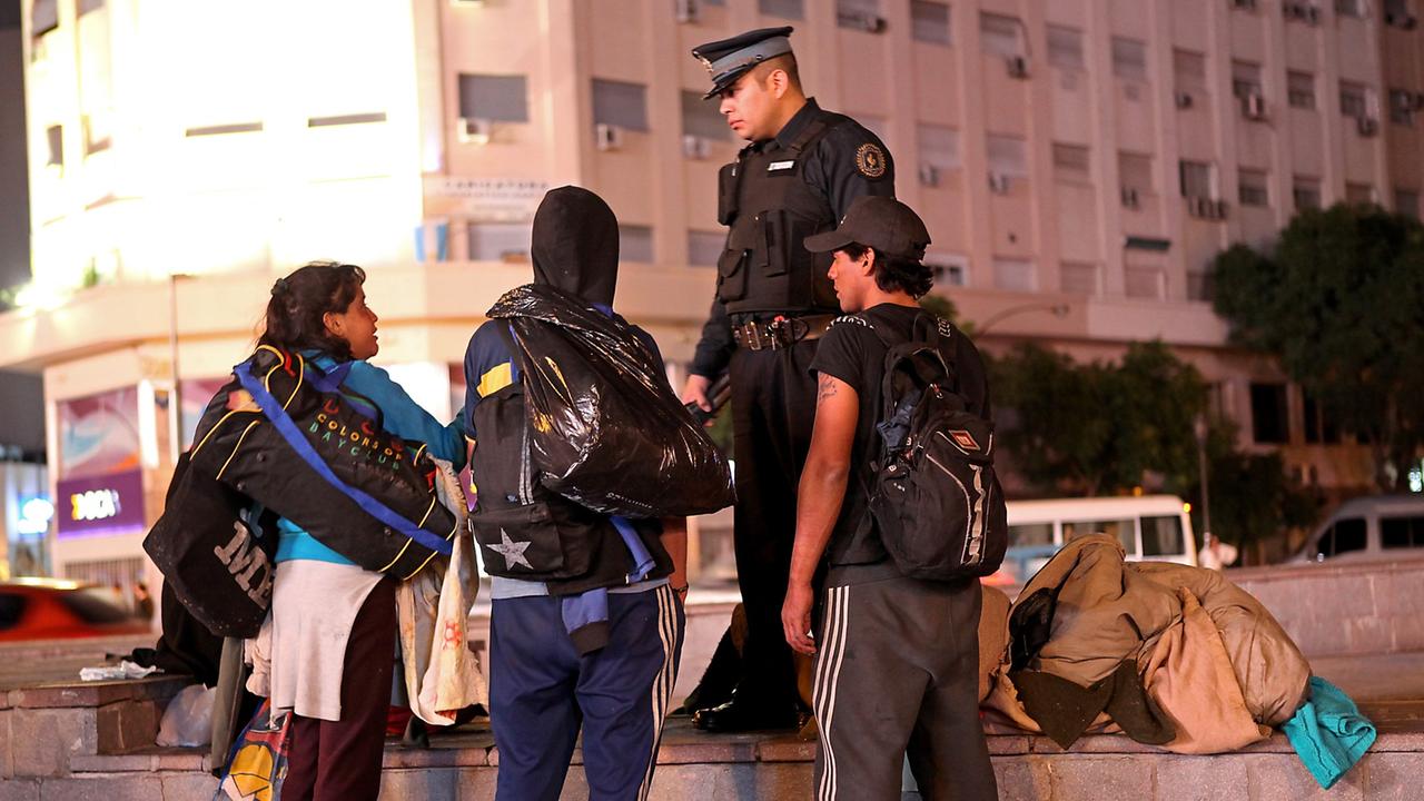 Die Innenstadt von Buenos Aires bei Nacht mit ihren ganz eigenen Bewohnern. - Ein Polizist im Gespräch mit Obdachlosen.