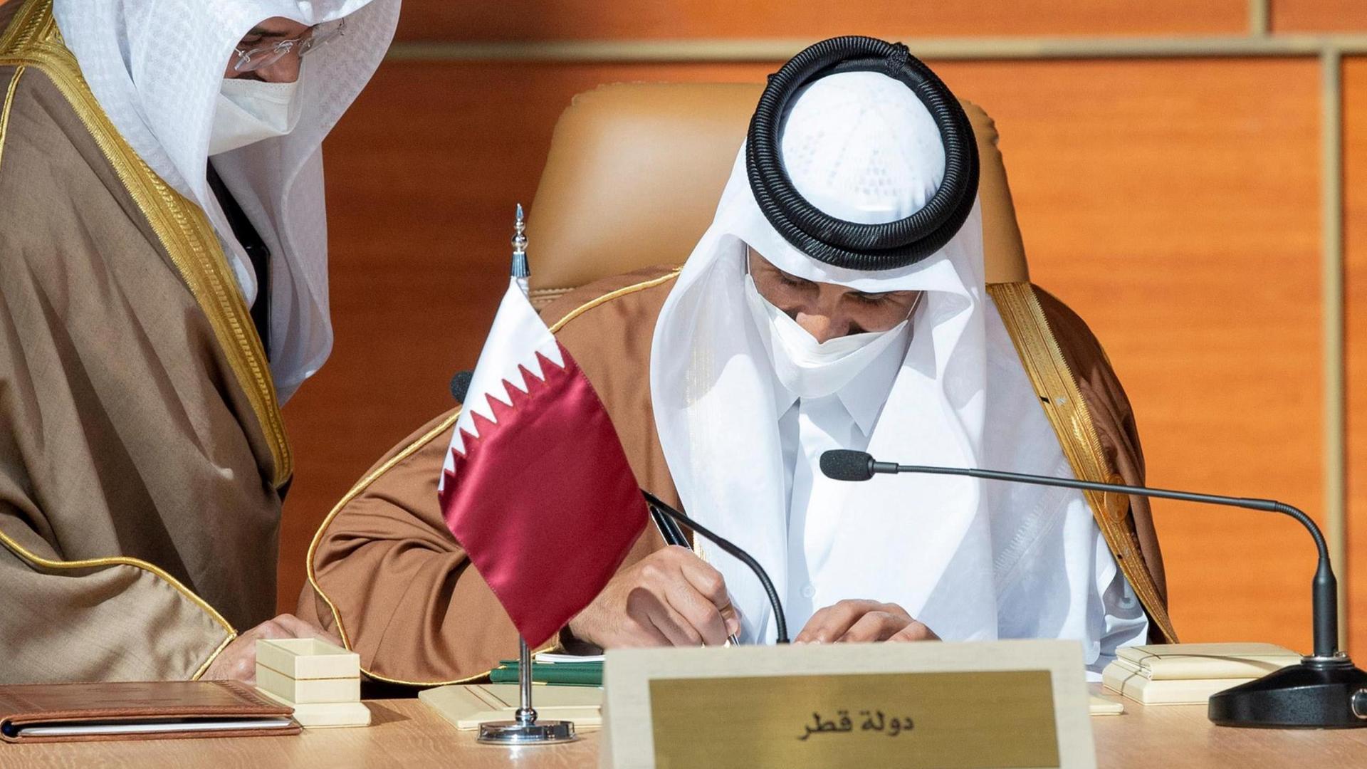 Das Foto zeigt den Emir von Katar, der einen Vertrag unterschreibt.