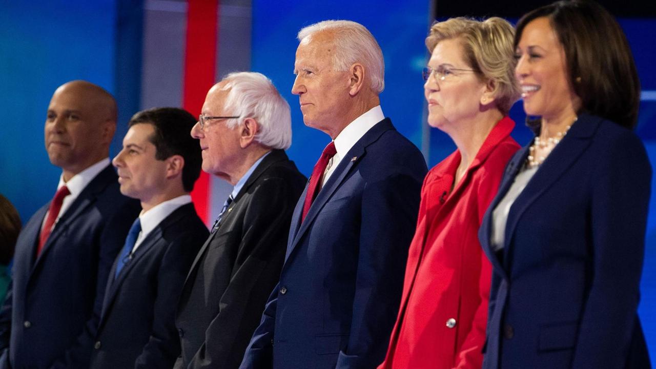 Debattenrunde mit dem demokratischen Kandidaten Cory Booker (l), Pete Buttigieg, Bernie Sanders, Joe Biden, Elizabeth Warren und Kamla Harris im September 2019 in Houston. Sechs Menschen stehen in einer Reihe auf einer Bühne.