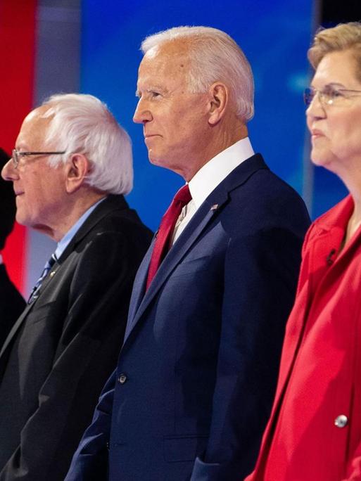 Debattenrunde mit dem demokratischen Kandidaten Cory Booker (l), Pete Buttigieg, Bernie Sanders, Joe Biden, Elizabeth Warren und Kamla Harris im September 2019 in Houston. Sechs Menschen stehen in einer Reihe auf einer Bühne.