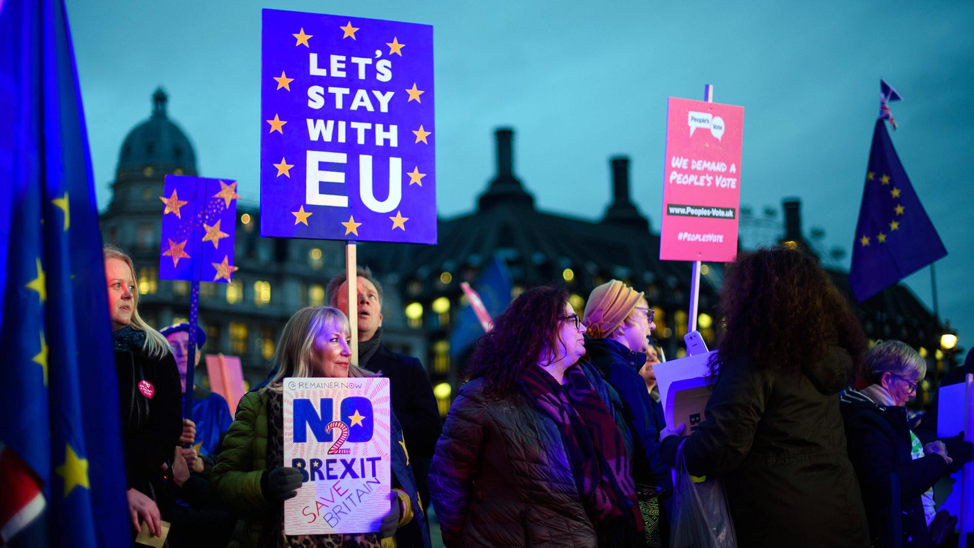 Demonstranten, die den Brexit ablehnen, halten am 15.1.2019 in London Schilder mit der Aufschrift "Let's stay with the EU" und "No 2 Brexit".