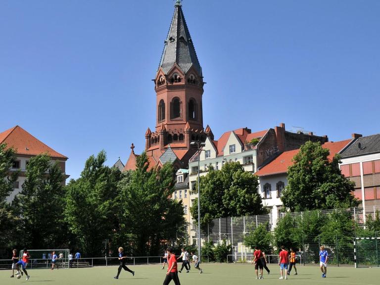 Sportplatz an der Gneisenaustraße in Berlin Kreuzberg, hinten die Passionskirche am Marheinekeplatz.