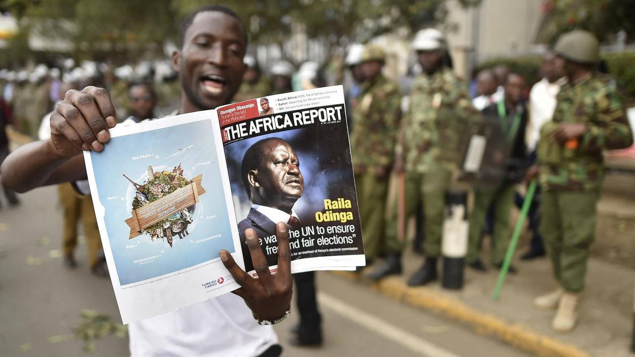 Ein Unterstützer der Oppositionspartei NASA in Kenia zeigt ein Magazin mit Oppositionsführer Raila Odinga auf dem Cover.