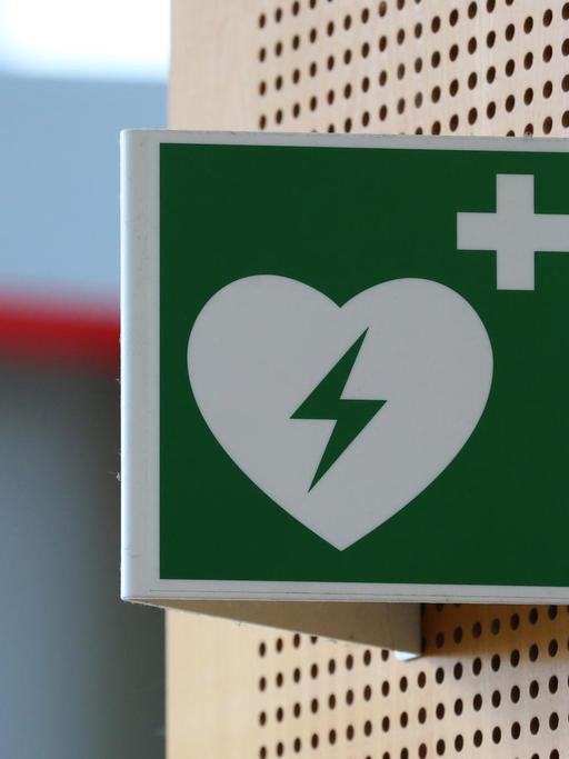 Ein Hinweisschild auf einen Defibrillator hängt im Strafjustizzentrum Augsburg (Bayern).