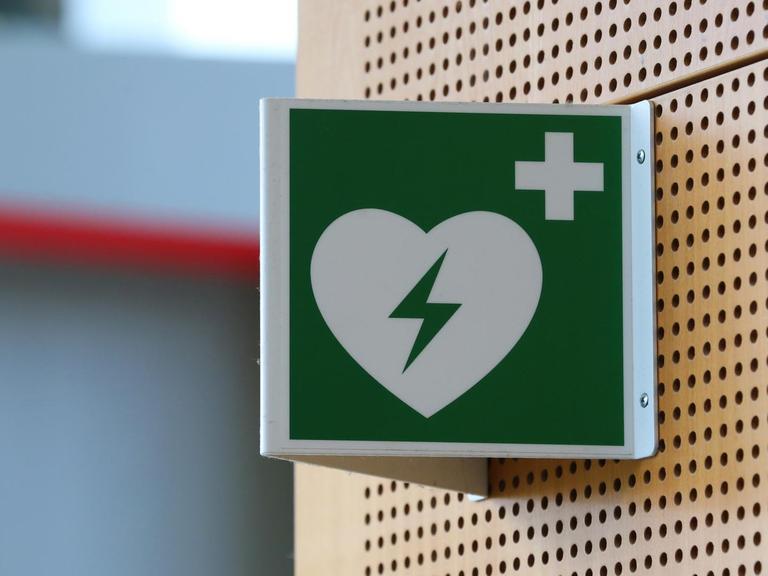 Ein Hinweisschild auf einen Defibrillator hängt im Strafjustizzentrum Augsburg (Bayern).