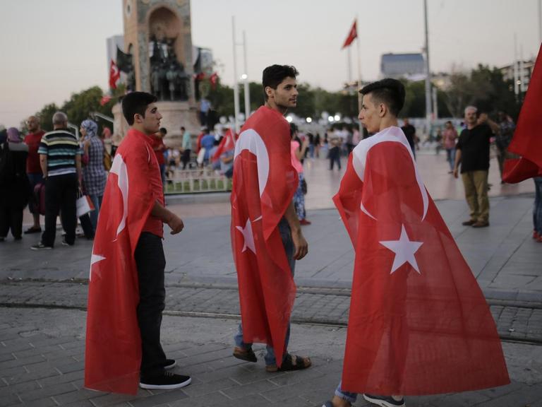 Junge Männer mit Türkeiflagge stehen einen Tag nach dem gescheiterten Militärputsch auf dem Taksim-Platz in Istanbul.