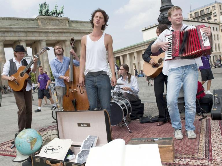 Musiker Felix Meyer (3.v.l) und Band musizieren auf dem Pariser Platz vor dem Brandenburger Tor in Berlin.