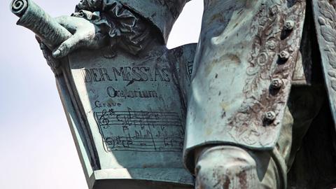 Detailblick auf die rechte Hand des Händel-Denkmals in Halle/Saale, die die Partitur des Oratoriums "Der Messias" festhält