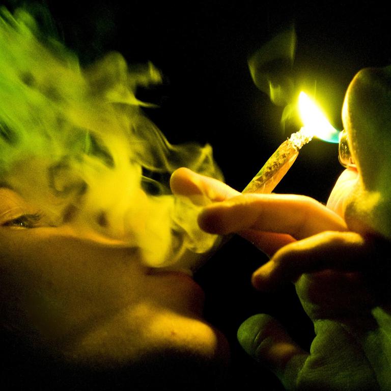 Ein Jugendlicher raucht einen Joint.