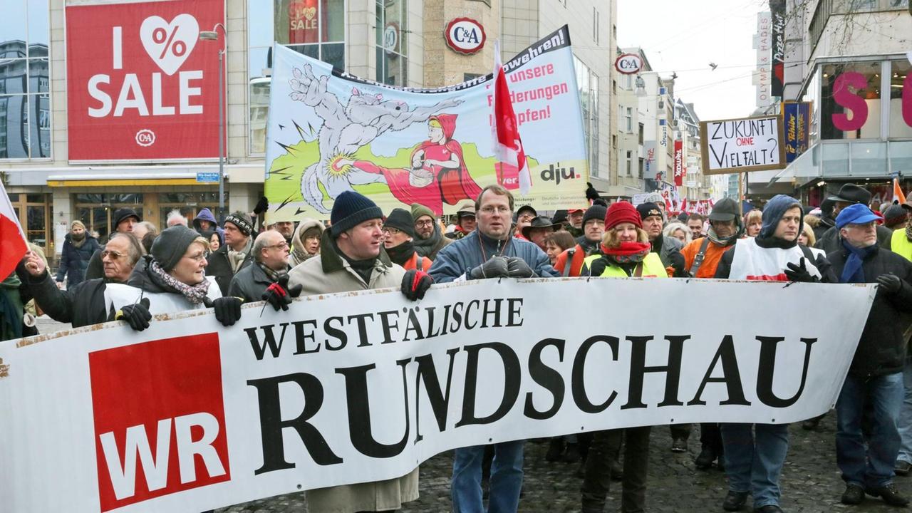 "Zukunft ohne Vielfalt?", heißt es es auf Transparenten und Plakaten der Demonstranten, die am 19.01.2013 in Dortmund gegen die Schließung der Redaktion der "Westfälischen Rundschau" protestierten. Sie halten außerdem das Logo der "Westfälischen Rundschau" hoch. Im Hintergrund ist ironischerweise eine C&A-Werbung mit der Aufschrift "I love Sale" zu lesen.