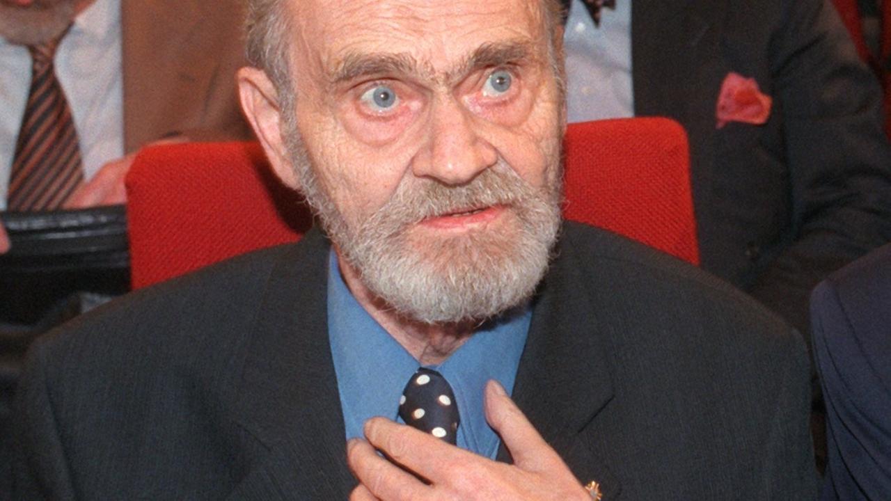 Der österreichische Lyriker H. C. Artmann im Anzug umd mit Vollbart während der Verleihung des Georg-Büchner-Preises 1997.