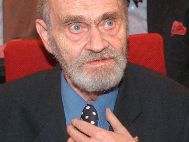 Der österreichische Lyriker H. C. Artmann im Anzug umd mit Vollbart während der Verleihung des Georg-Büchner-Preises 1997.
