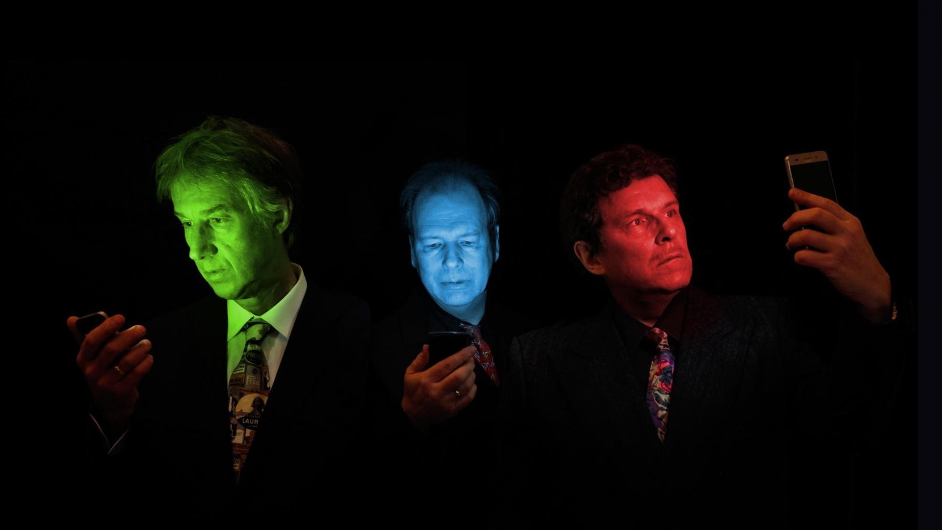 Frank Fenstermacher, Kurt Dahlke und Moritz Reichelt von Der Plan werden von ihren Smartphones grün, blau und rot angestrahlt. (Bild: Oliver Schultz-Berndt)