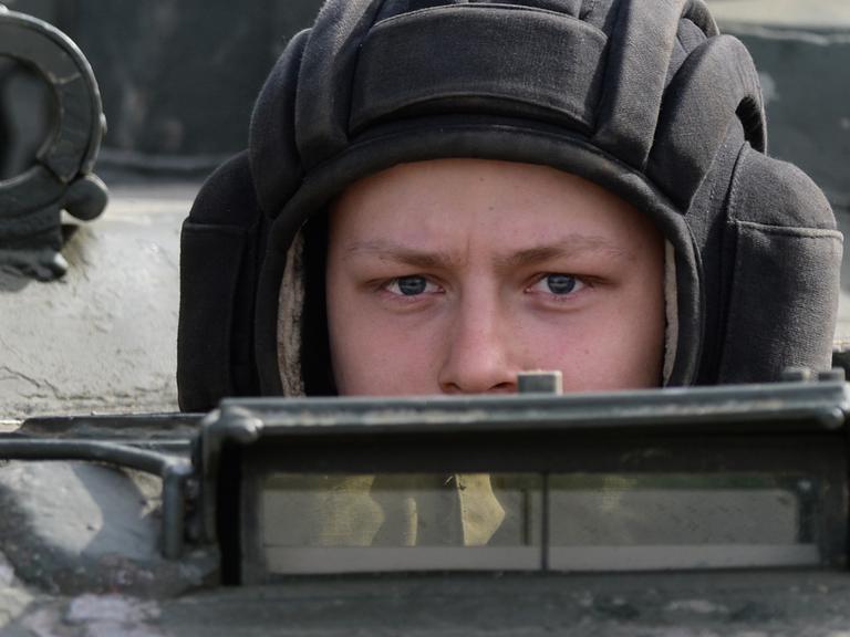 Ein russischer Soldat schaut aus einem Panzerfahrzeug