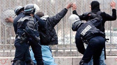 Französische Polizisten durchsuchen Personen in Paris.