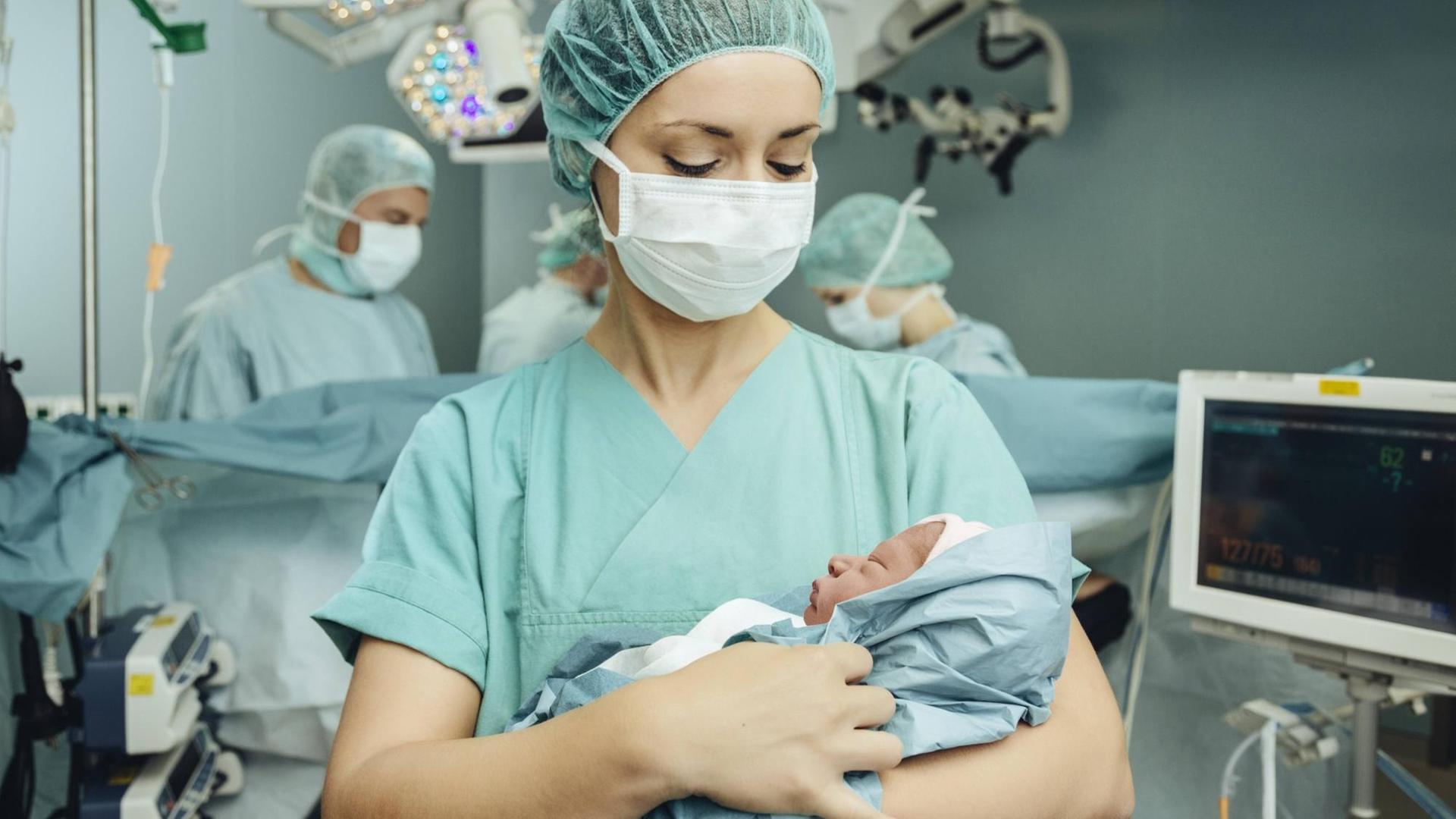 OP-Schwester mit frisch entbundenem Kaiserschnittbaby