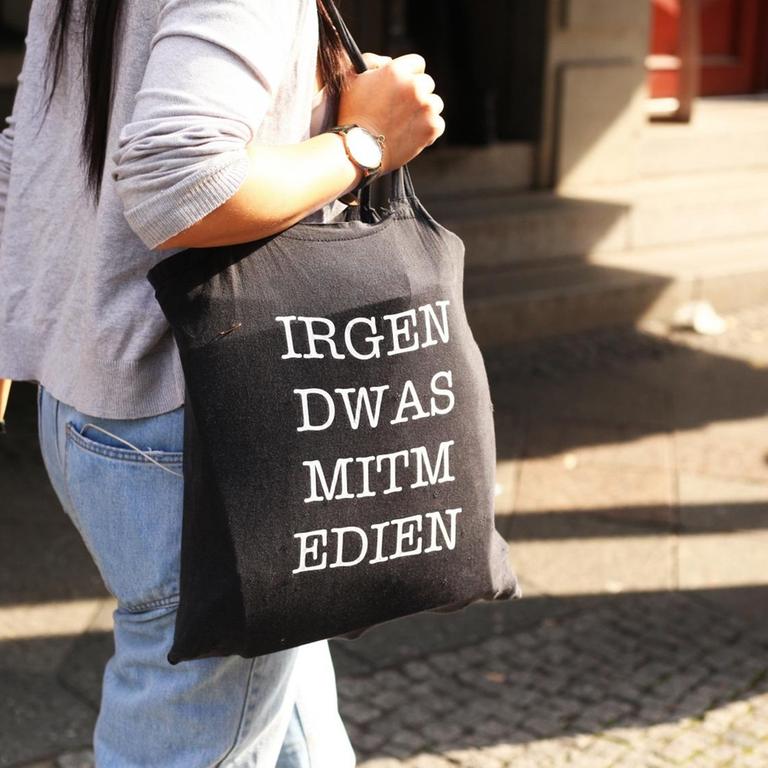 Eine junge Frau trägt am 28.09.2017 in Berlin im Stadtteil Mitte eine Jutetasche mit der Aufschrift "IRGEN DWAS MITM EDIEN" für "Irgendwas mit Medien".
