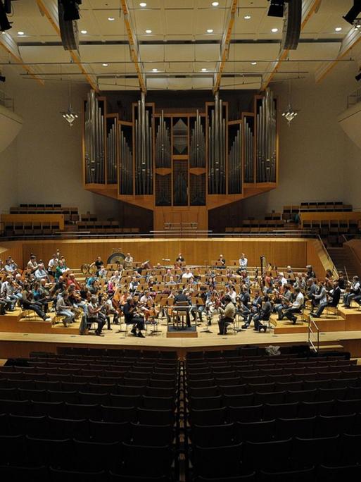Leere Ränge der Konzerthalle Bamberg. Auf der Bühne sind Musiker der Bamberger Symphoniker bei einer Probe.