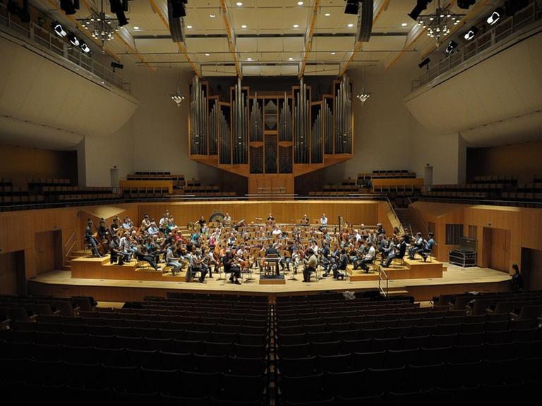 Leere Ränge der Konzerthalle Bamberg. Auf der Bühne sind Musiker der Bamberger Symphoniker bei einer Probe.