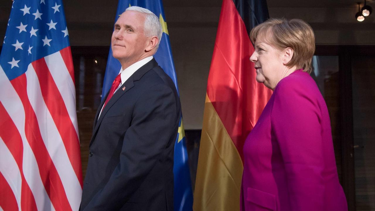 Bundeskanzlerin Angela Merkel (CDU. rechts im Bild) und Mike Pence, Vizepräsident der USA, begrüßen sich am zweiten Tag der 55. Münchner Sicherheitskonferenz zu Beginn eines Gesprächs.