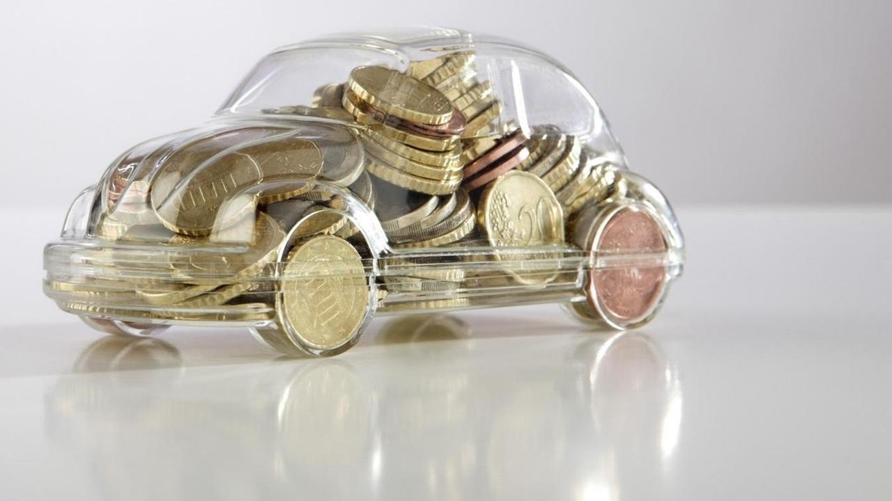 Symbolbild Spardose in Autoform, gefüllt mit Eurostücken. Mit einer Kaufprämie soll der Absatz von Neufahrzeugen angekurbelt werden.