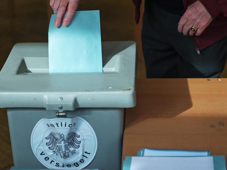 Ein Stimmzettel wird in einem Wahllokal im österreichischen Wien in eine Urne geworfen.