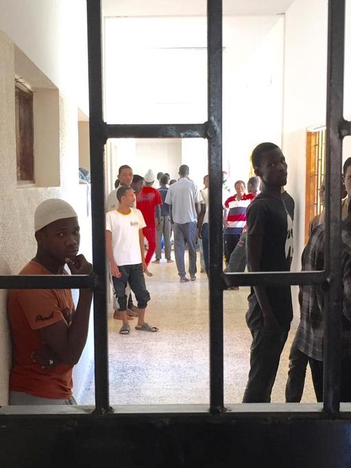 Migranten stehen im Auffanglager für Flüchtlinge in Misrata (Libyen) hinter Gittern.