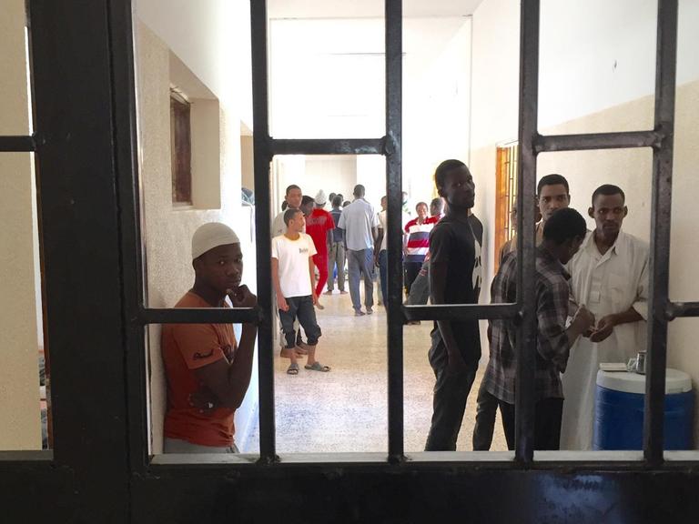 Migranten stehen im Auffanglager für Flüchtlinge in Misrata (Libyen) hinter Gittern.