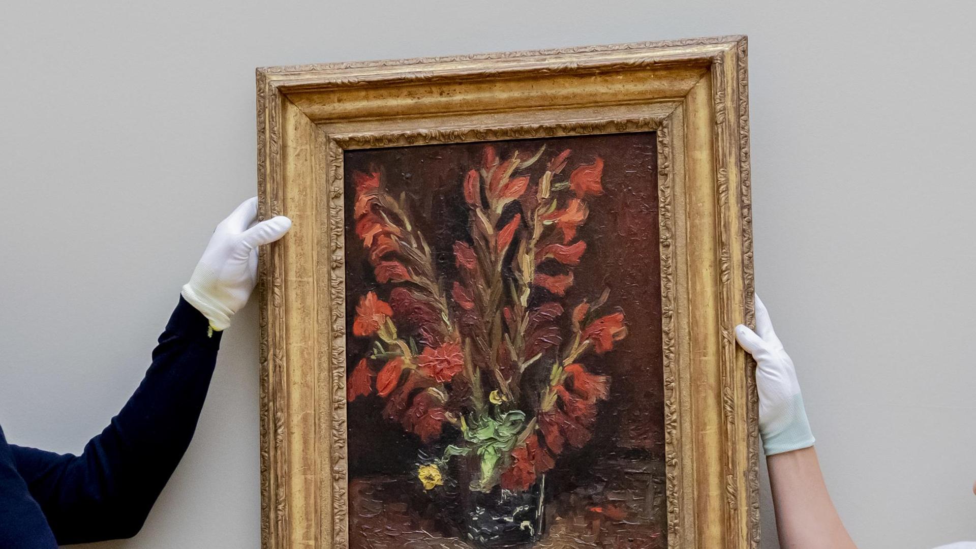 Zwei Mitarbeiter des Aufbauteams hängen beim Aufbau der Ausstellung „Van Gogh. Stillleben" im Museum Barberini das Werk „Vase mit roten Gladiolen, 1886" des Malers Vincent van Gogh