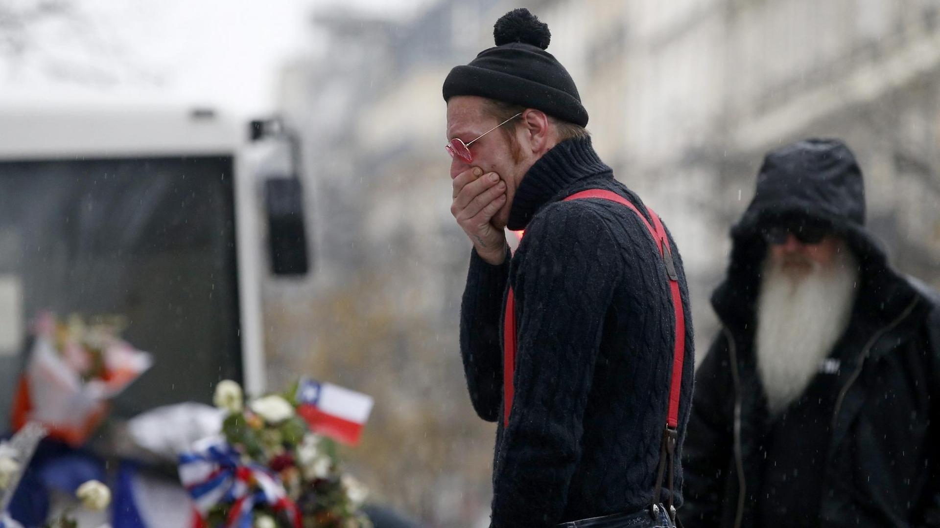 Man sieht den Musiker Jesse Hughes von den "Eagles of Death Metal". Er steht vor vielen Blumen am Konzert-Saal Bataclan in Paris. Man sieht den Musiker Jesse Hughes von den "Eagles of Death Metal". Er steht vor vielen Blumen am Konzert-Saal Bataclan in Paris.