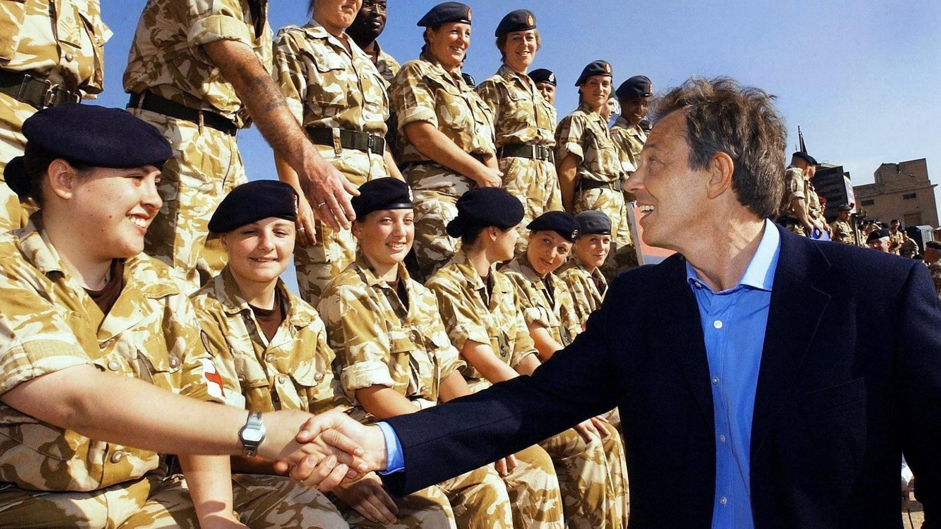Tony Blair schüttelt einer Soldatin in einer Reihe von Kameradinnen die Hand