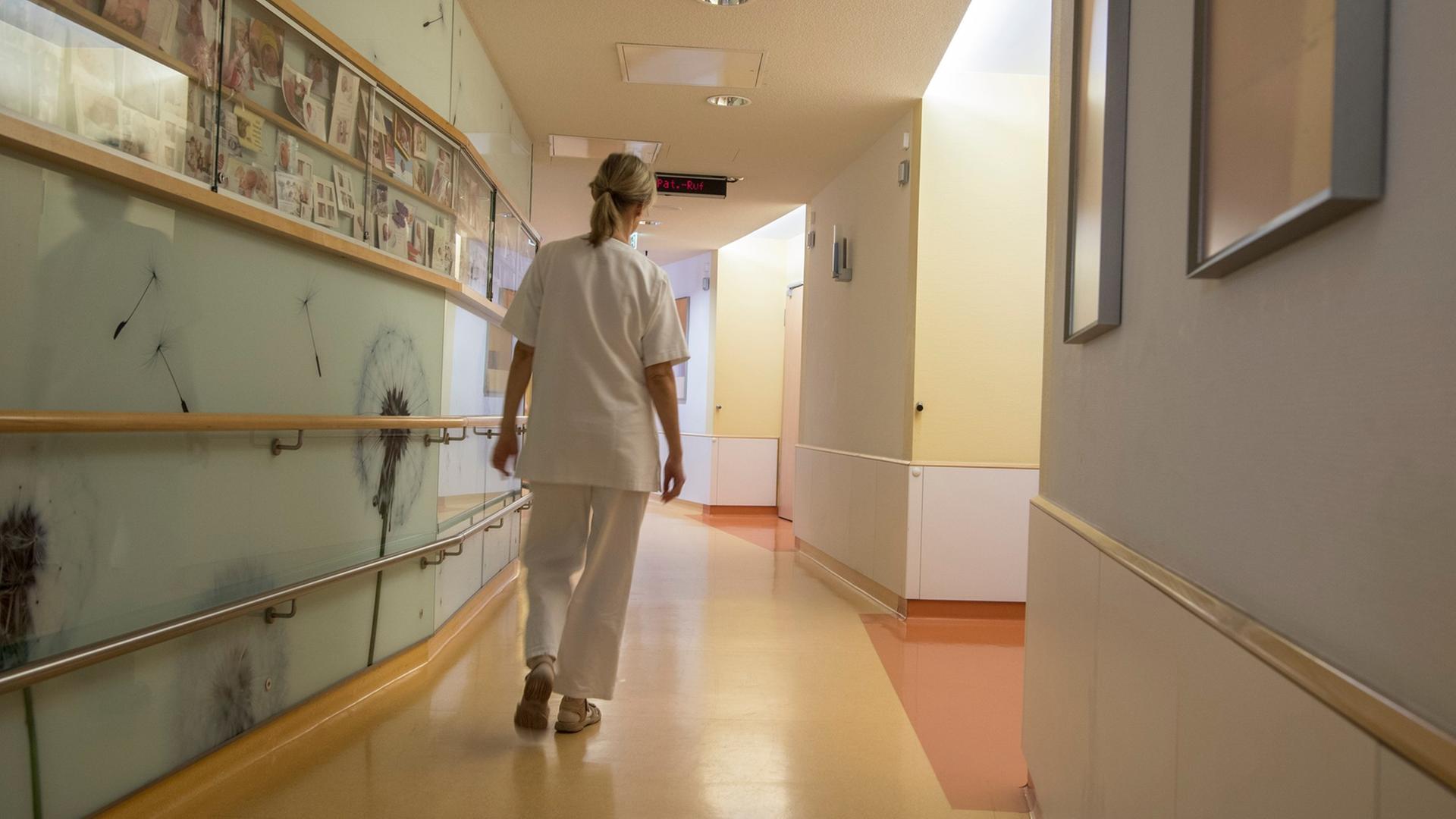 Eine Krankenschwester geht über den ansonsten leeren Flur der Neugeborenen-Station des Bürger-Hospitals in Frankfurt am Main.