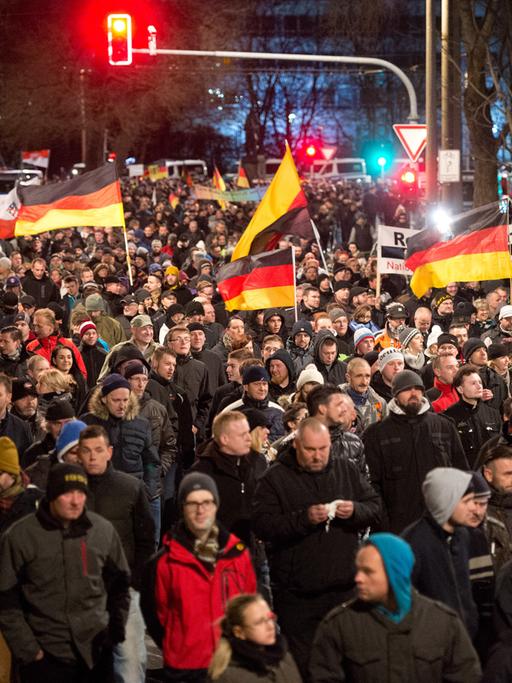 Eine Menschenmenge marschiert mit Deutschlandflaggen durch Dresden.