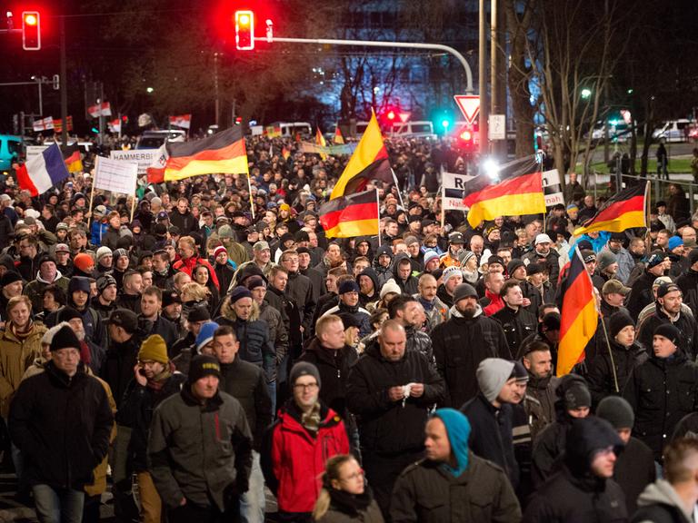 Eine Menschenmenge marschiert mit Deutschlandflaggen durch Dresden.