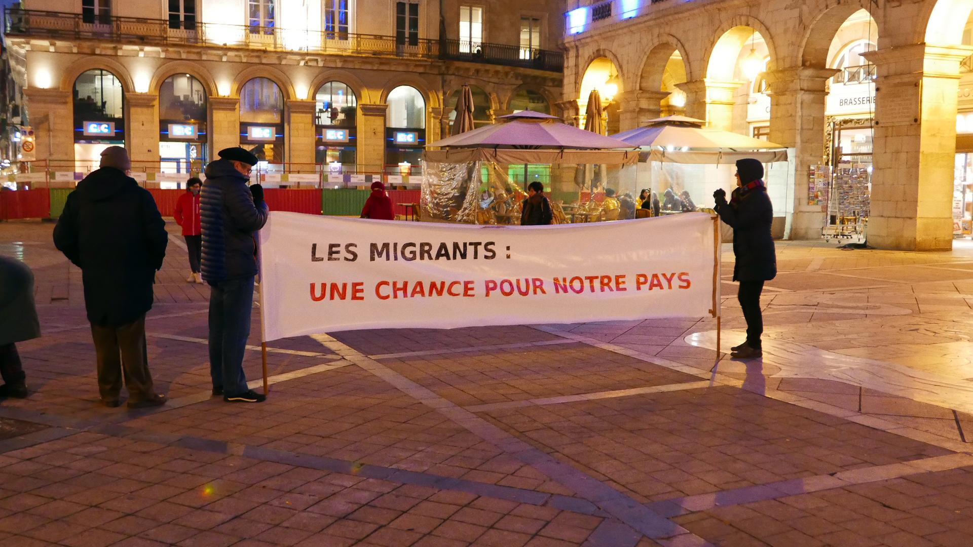 Jean-Baptiste und seine Frau halten das Transparent mit dem Titel Migranten Eine Chance für unser Land