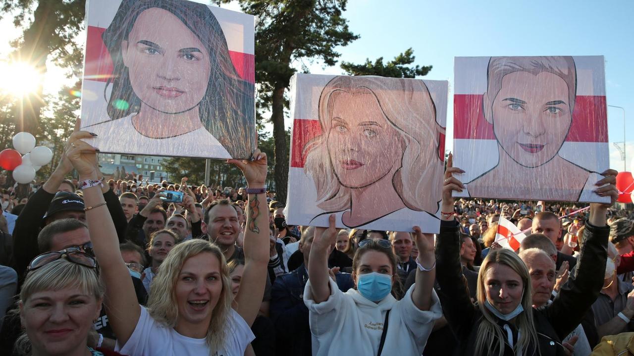 Belarus: Frauen halten Porträts von den Politikerinnen Sviatlana Tsikhanouskaya, Veronika Tsepkalo and Maria Kolesnikova in die Höhe. 
