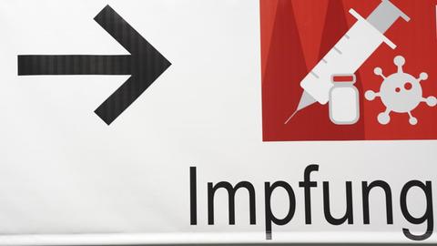 Ein Schild weist den Weg im Impfzentrum in der Messe Köln