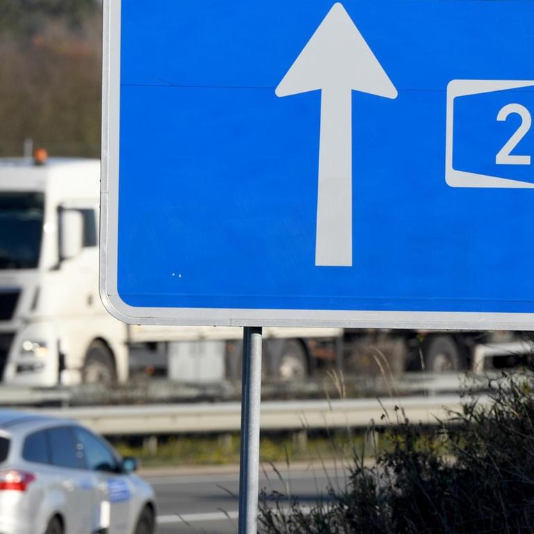 Autos fahren hinter einem Hinweisschild zur A20 auf der Autobahn.